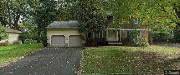 Single-family home at 911 Morris Avenue in Westfield, NJ featuring a two-car garage, brick exterior, and tree-lined suburban setting